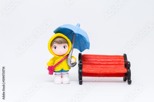 Miniature girl holding blue umbrella isolate on white background, rainy season concept, school girl in raincoat on white background