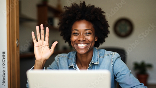 Happy black woman waving during video call at home
