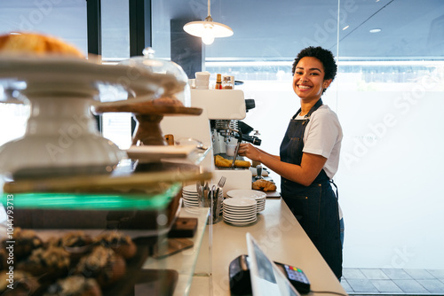 Bakery, happy portrait of black woman in cafe ready for serving pastry, coffee and baked foods. Restaurant, coffee shop and confident waiter barista by counter for service, help and welcome