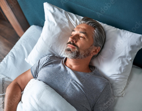 handsome bearded man sleeping middle aged guy grey hair sleeping lying with closed eyes in comfortable bed in bedroom home photo