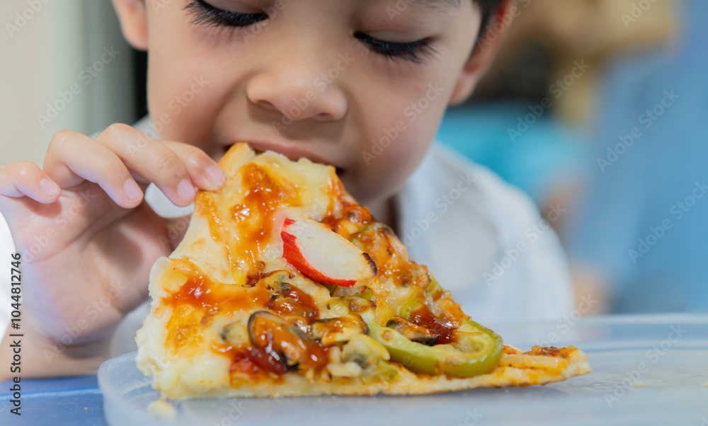 A little white boy with a smile on his face is eating a piece of delicious hot pizza. A little white boy with a smile on his face is eating a piece of delicious hot pizza.