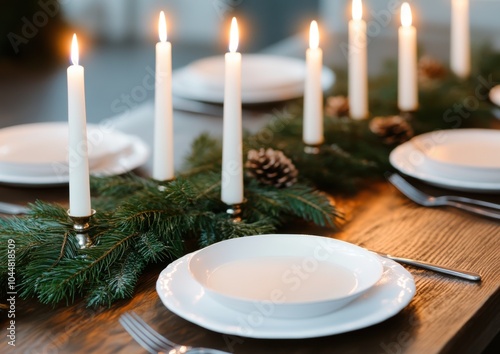 A beautifully set dining table adorned with white plates, candles, and pine accents, perfect for a festive gathering. photo