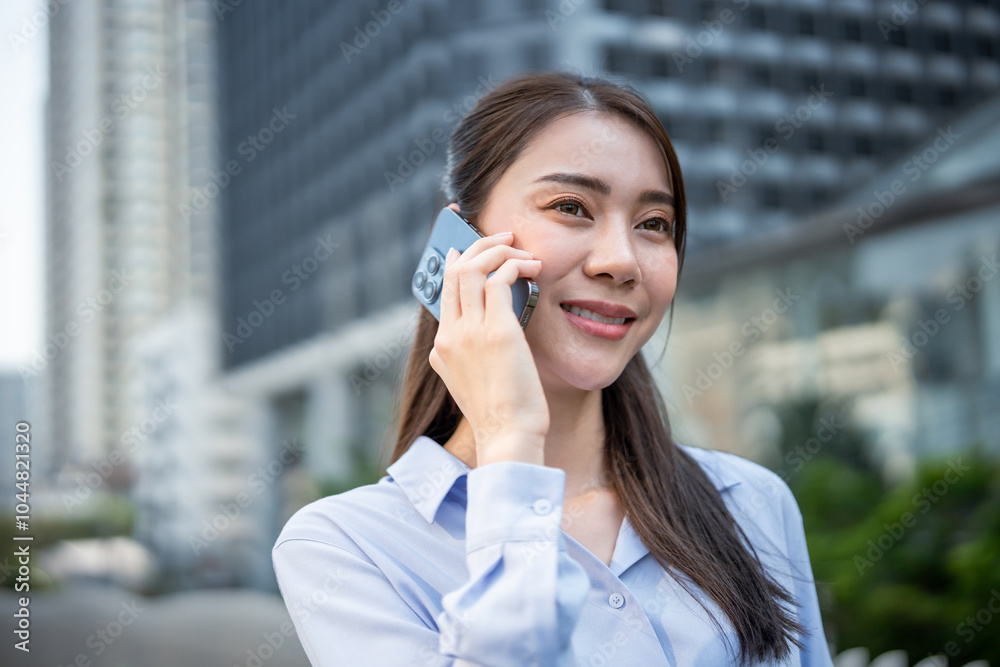 Asian young businesswoman talking on smartphone while walk in the city. Asian young businesswoman talking on smartphone while walk in the city.