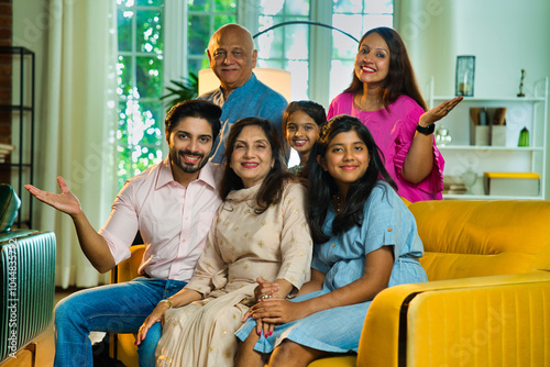 Photography Closeup of Indian family of six sitting together on a sofa in a lavish home, joy