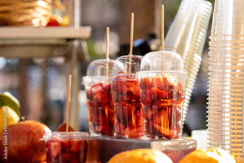 Fresh Cut Strawberries in Plastic Cups Street Food Style, Summer Fruit Market Stand, Ready to Eat Snack photo