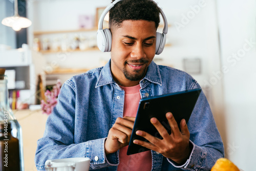 Handsome young hispanic man sitting in a bar cafeteria -  heerful african-american male relaxing in a pastry bakery coffee shop photo