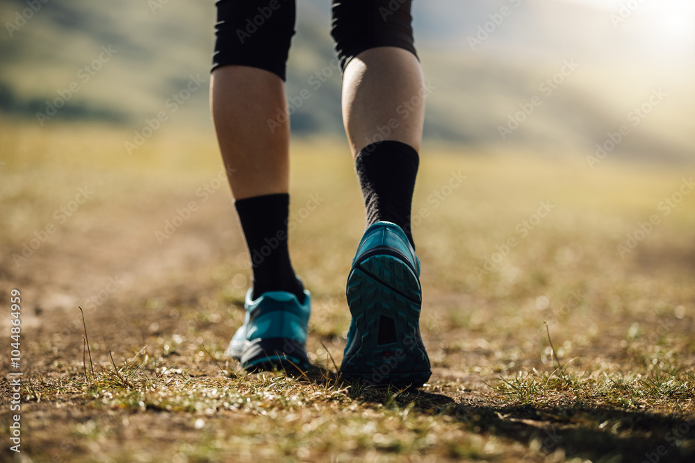Fitness woman legs walking on high altitude grassland mountain road Fitness woman legs walking on high altitude grassland mountain road
