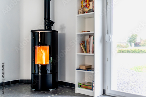 Fotografie Pellet stove in a living room with bookcase and heat diffuser