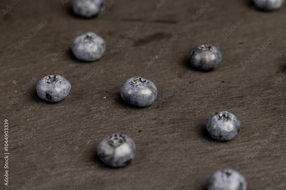blueberries scattered on a black slate board