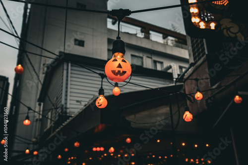 Fototapeta Naklejka Na Ścianę i Meble -  Halloween street decoration small orange lamps in the shape of pumpkins on the city street