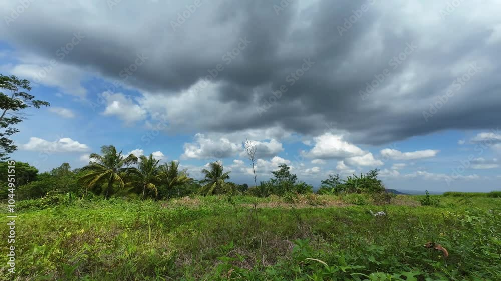 Timelapse of thick clouds during the day over Indonesian fields. 4K quality footage Timelapse of thick clouds during the day over Indonesian fields. 4K quality footage