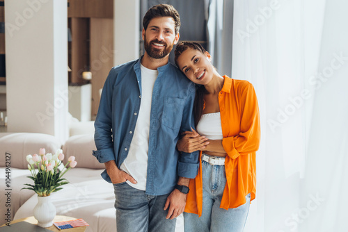 Portrait of positive happy Hispanic couple wearing colorful clothes looking at camera, fashion model photo