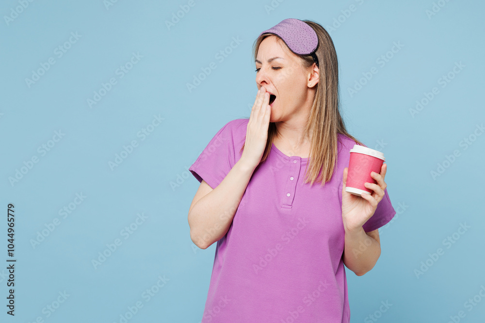 Calm young woman wear purple pyjamas jam sleep eye mask rest relax at home hold takeaway delivery craft paper cup coffee to go isolated on plain light blue cyan background Good mood night nap concept Calm young woman wear purple pyjamas jam sleep eye mask rest relax at home hold takeaway delivery craft paper cup coffee to go isolated on plain light blue cyan background Good mood night nap concept