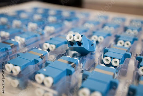 Optical adapters with different connectors in plastic blisters on the table, a batch of goods	
