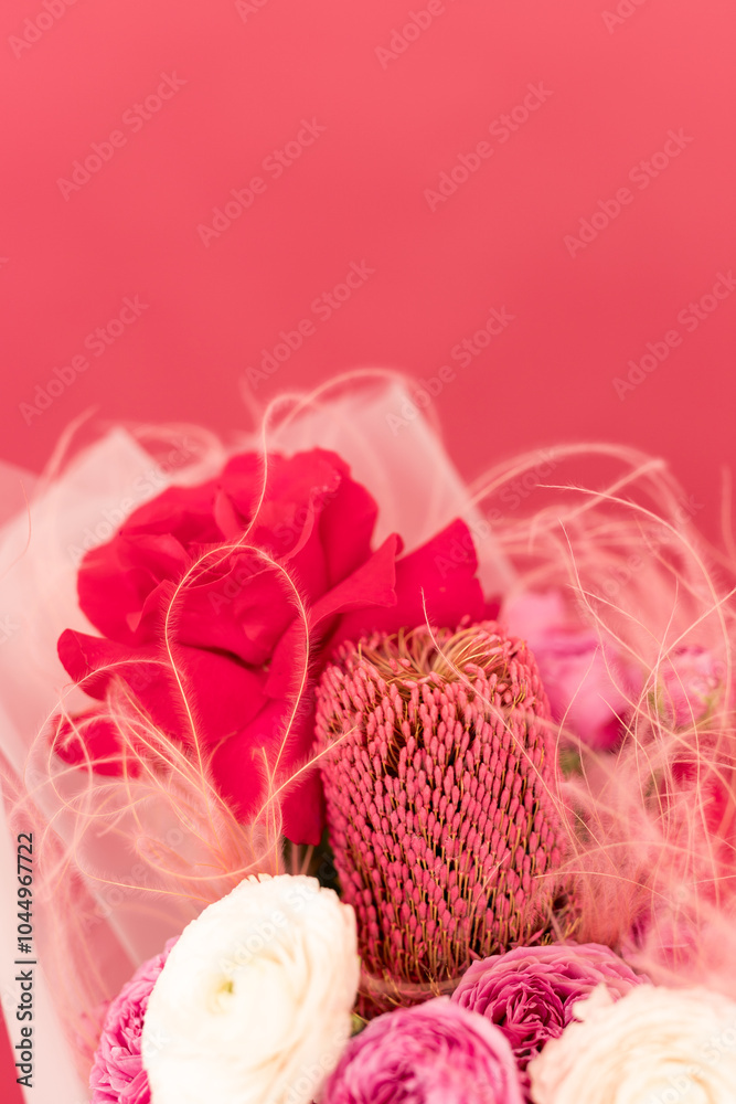 A vibrant bouquet of pink and red flowers beautifully arranged against a soft pink backdrop, creating a stunning display of nature's artistry A vibrant bouquet of pink and red flowers beautifully arranged against a soft pink backdrop, creating a stunning display of nature's artistry