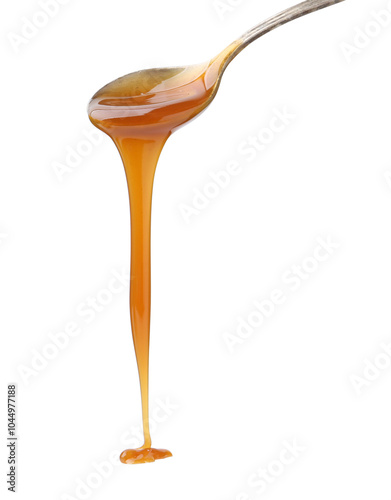 Tasty caramel sauce dripping from spoon on white background, closeup photo