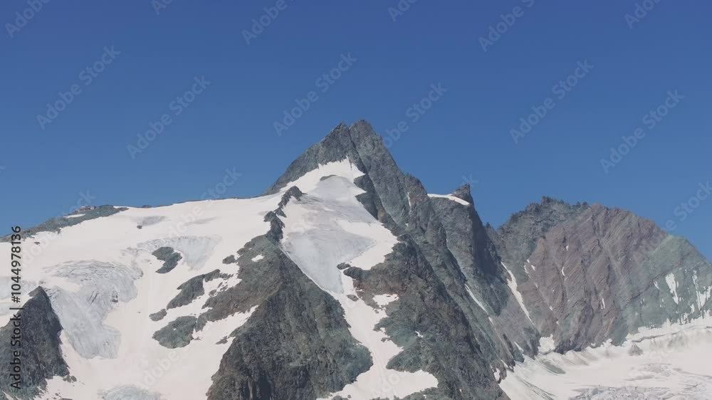 Medium tele camera captures Grossglockner peak covered in snow and ice - 4K.