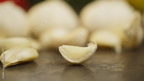 A close-up of a clove of garlic spinning on the table. Slow motion background video of vegetables. High quality FullHD footage