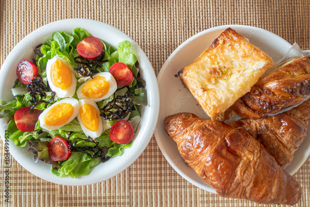 Green vegetable salad with leave,tomatoes,boiled eggs and microgreen on white plate on wooden table background Green vegetable salad with leave,tomatoes,boiled eggs and microgreen on white plate on wooden table background