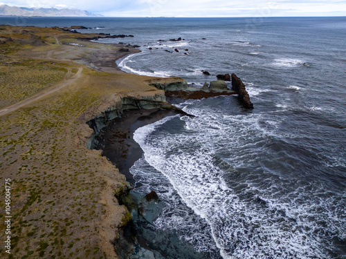 Panorama of Laekjavik beach rock formation sea stack black sand atlantic ocean coast tower east fjords Iceland Europe photo