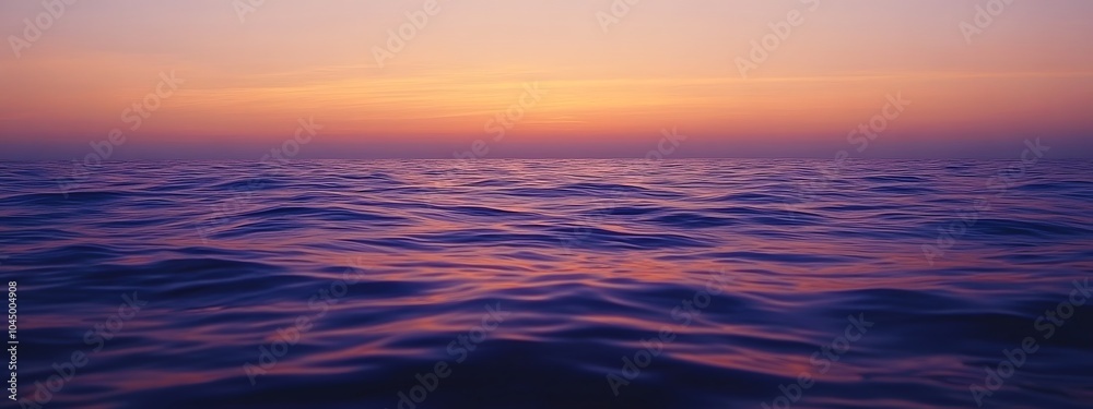 Obraz premium A calm sea at sunset, with the horizon blending into a gradient of purples and oranges, creates an atmosphere that feels serene and peaceful.