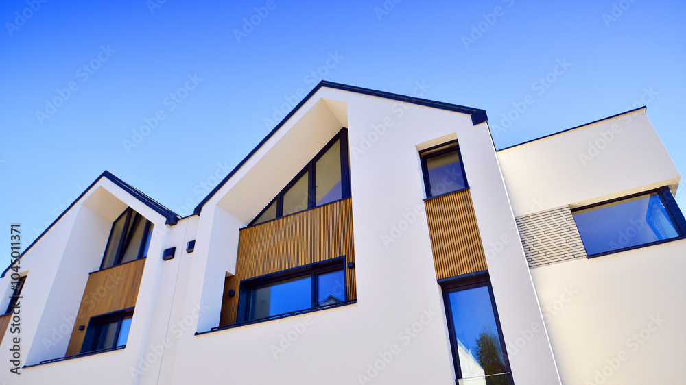 Residential homes with modern facade.Terraced family homes in newly developed housing estate. The real estate market in the suburbs. New single family houses in a new development area. Residential homes with modern facade.Terraced family homes in newly developed housing estate. The real estate market in the suburbs. New single family houses in a new development area.