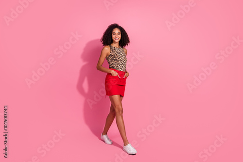 Full body photo of attractive young girl walking enjoy black friday dressed stylish leopard print clothes isolated on pink color background