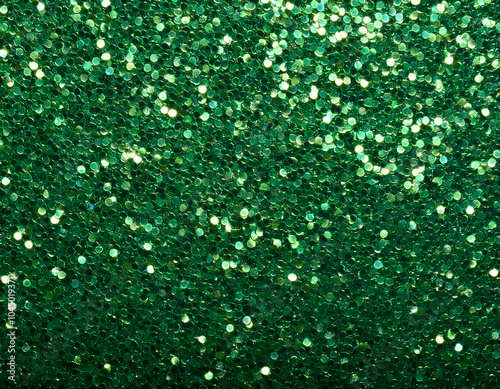 a green glitter surface with both fine and chunky sparkles reflecting light in random directions, forming a textured abstract pattern