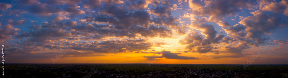 Panorama Top view Aerial photo from flying drone over rice fields in Thailand.Cumulus sunset clouds with sun setting down on dark background. Panorama Top view Aerial photo from flying drone over rice fields in Thailand.Cumulus sunset clouds with sun setting down on dark background.