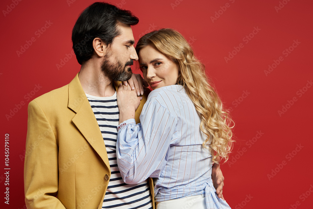A middle aged couple shares an intimate moment in a creatively styled setting with bright colors. A middle aged couple shares an intimate moment in a creatively styled setting with bright colors.