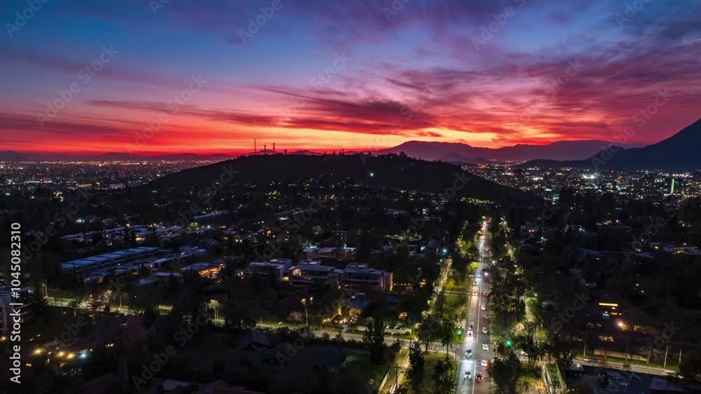 Aerial hyperlapse establishing with a sunset in the background in Las Condes, Santiago at night, cars passing by, streets with traffic. Aerial hyperlapse establishing with a sunset in the background in Las Condes, Santiago at night, cars passing by, streets with traffic.