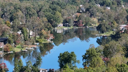 Aerial establishing shot of idyllic Timber lake with Houses during autumnal day. Sunny day in beautiful landscape. Wide shot. photo