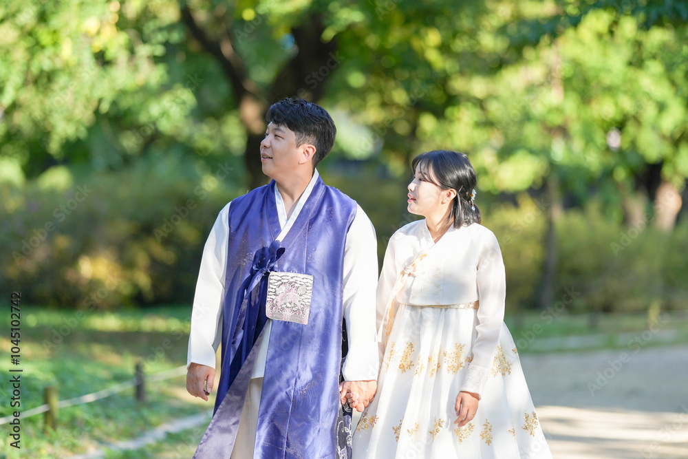 A Korean couple, a man in his 30s and a woman in her 20s, are spending time together in a historic park in Seoul, South Korea. A Korean couple, a man in his 30s and a woman in her 20s, are spending time together in a historic park in Seoul, South Korea.