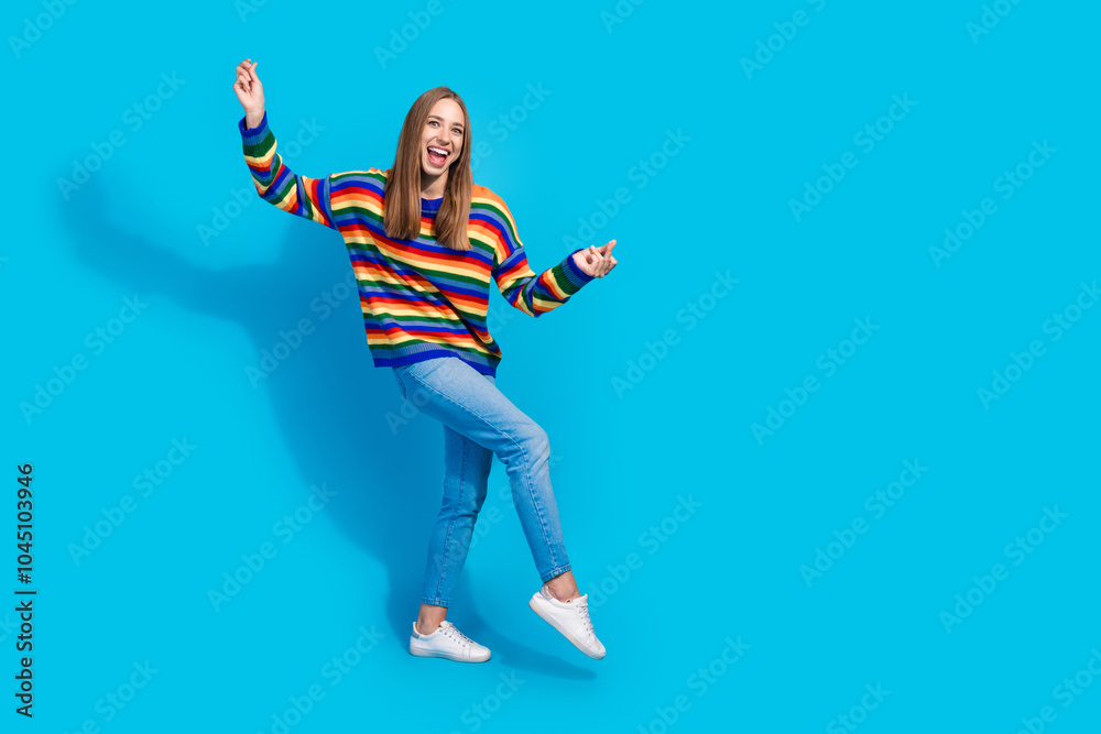 Photo of carefree cheerful girl wear striped colorful stylish clothes have fun dance isolated on blue background Photo of carefree cheerful girl wear striped colorful stylish clothes have fun dance isolated on blue background