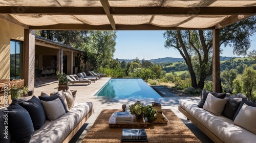 Spacious outdoor lounge under a contemporary pergola  with soft cushions and a pool view.