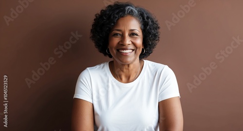 mixed race mature woman brown background wearing plain white tshirt smiling happy portrait