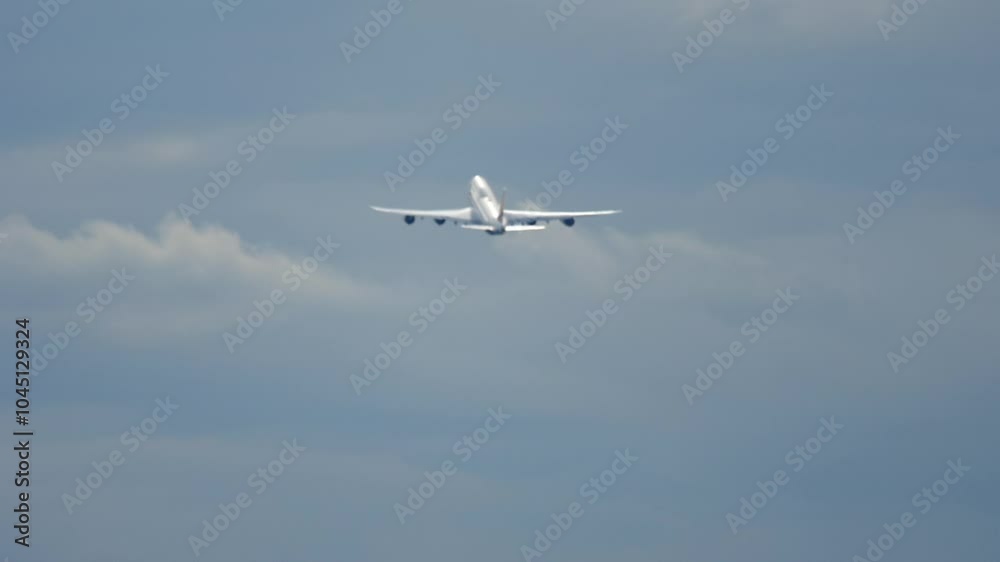 Heavy widebody jet aircraft climbing after takeoff. Slow motion footage of the airliner flying away Heavy widebody jet aircraft climbing after takeoff. Slow motion footage of the airliner flying away