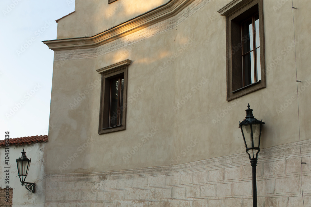 There is a charming building that features a lamp beautifully mounted on its side, illuminating its facade in the twilight There is a charming building that features a lamp beautifully mounted on its side, illuminating its facade in the twilight