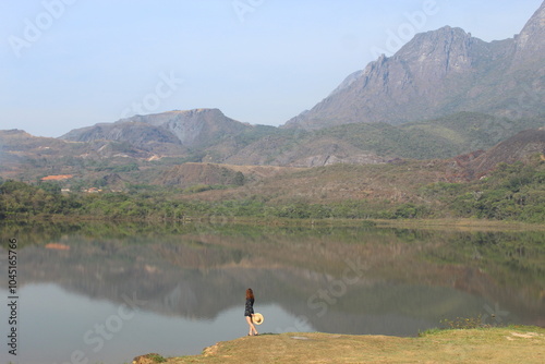 pessoa nas margens da represa do mosquito com serra do caraça ao fundo em catas altas, minas gerais  photo