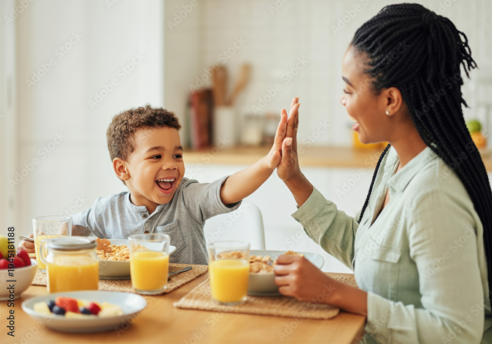 A joyful morning breakfast between a mother and her son in a sunny kitchen filled with laughter and delicious food A joyful morning breakfast between a mother and her son in a sunny kitchen filled with laughter and delicious food