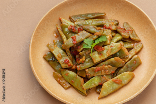 Homemade taze fasulye - Turkish style stewed runner beans on a plate. Popular meze and summer food made of runner bean, onion, garlic, tomatoes, and a large quantity of olive oil. photo