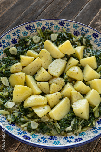 Potatoes with leaf beet and garlic on a plate. South Croatian Blitva dish made with boiled potatoes, swiss chard, garlic, and olive oil. photo