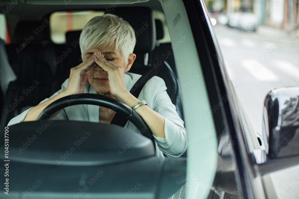 Senior businesswoman feeling stressed while in car Senior businesswoman feeling stressed while in car