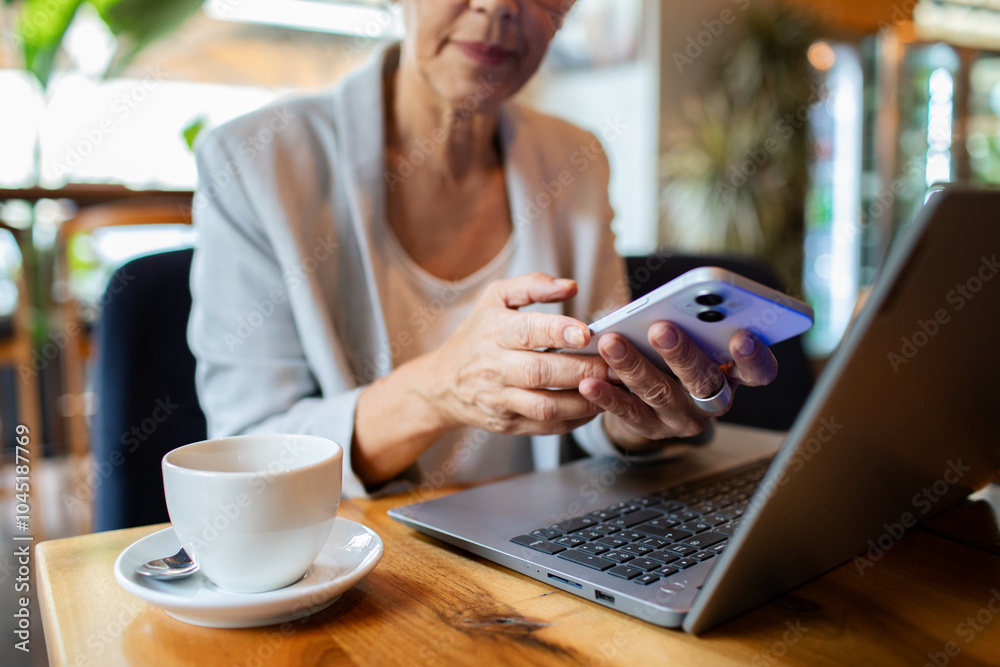 Senior businesswoman using smartphone in cafe Senior businesswoman using smartphone in cafe