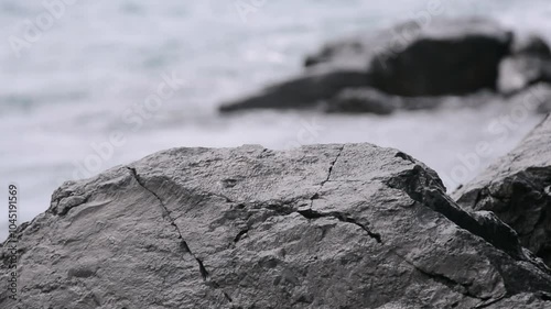 Waves crash against the coastal rocks and create spray