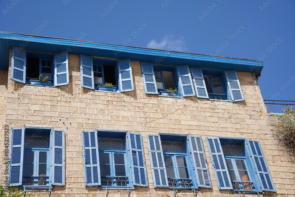 Obraz premium View of beautiful building with blue shutters in old jaffa