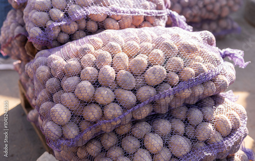 A vibrant scene of a pile of fresh potatoes in various sizes and colors, displayed in a farmer s market stall, surrounded by other fresh vegetables. photo