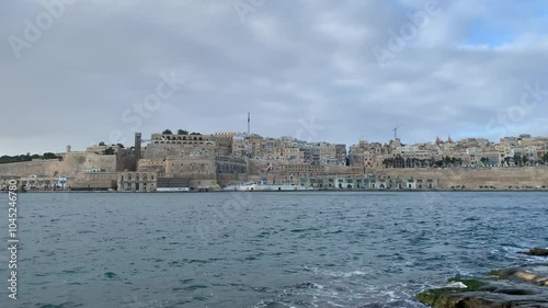 Panoramic, scenic view of Valletta city skyline. Upper Barrakka Gardens, Saluting Battery, St Barbara Bastion, Victoria Gate in the background. Motion of sea waves. Valletta, Malta photo