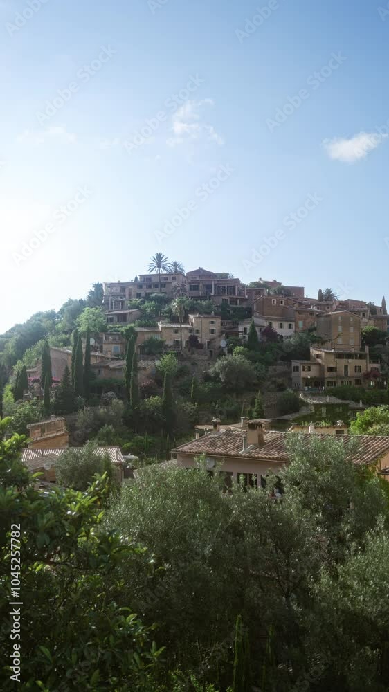 Scenic view of deia in mallorca with hillside houses and lush greenery under a clear blue sky showing the picturesque balearic village Scenic view of deia in mallorca with hillside houses and lush greenery under a clear blue sky showing the picturesque balearic village