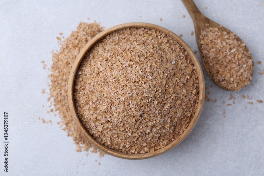 Buckwheat bran in bowl and spoon on light grey table, top view Buckwheat bran in bowl and spoon on light grey table, top view